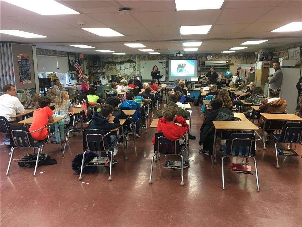 A group of diverse children sitting at desks in a classroom