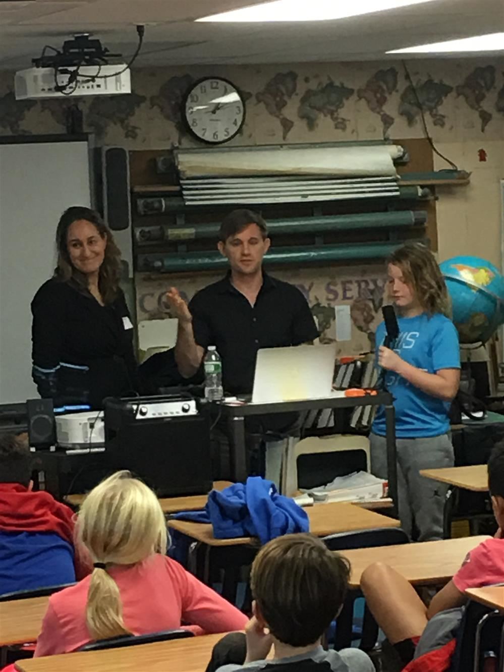 A teacher instructing a diverse group of students in a classroom setting.