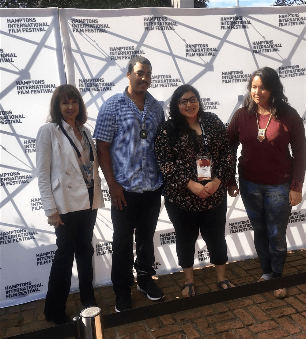 Group of people posing in front of a banner.