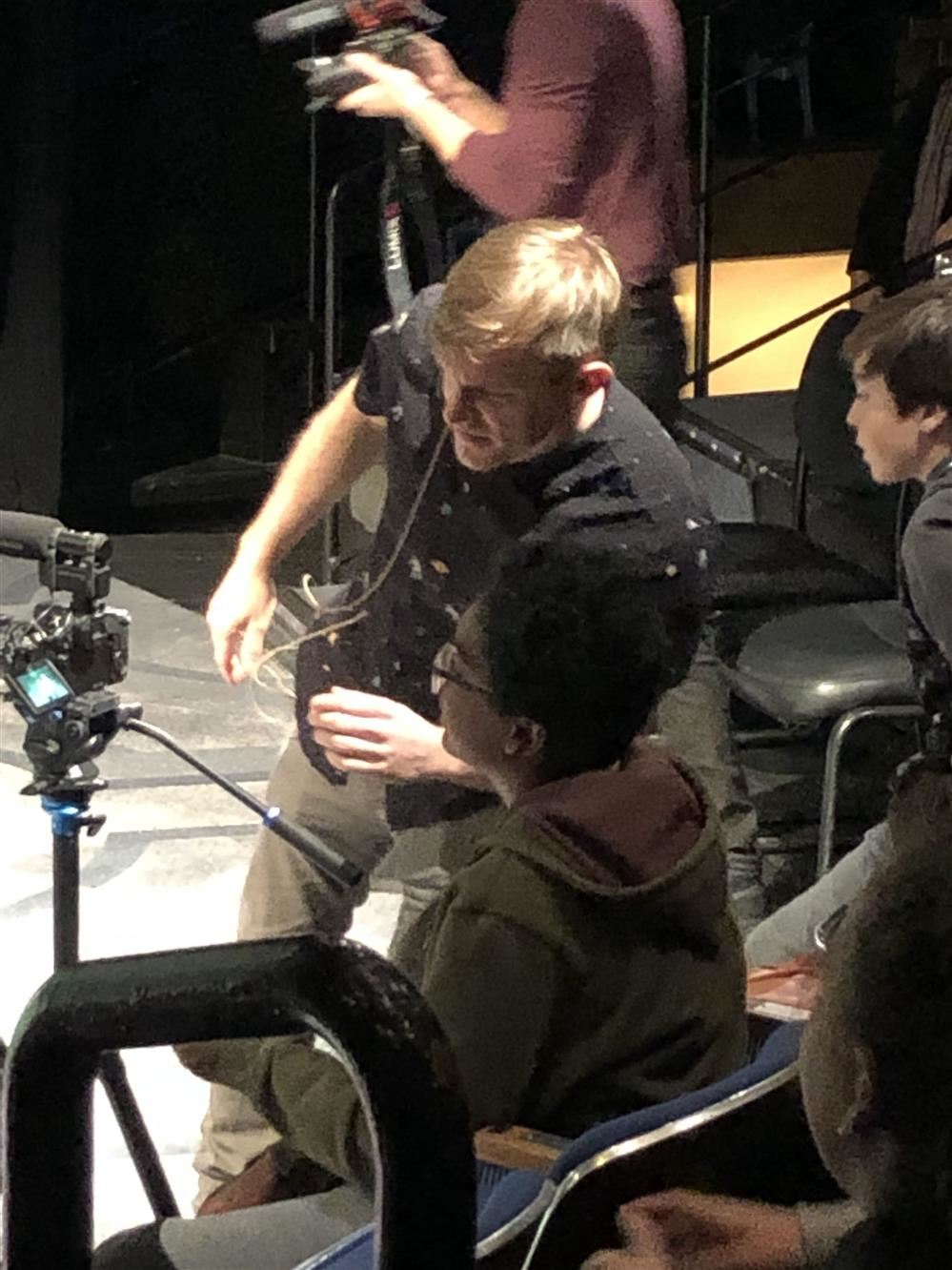 A man filming a scene with a camera.