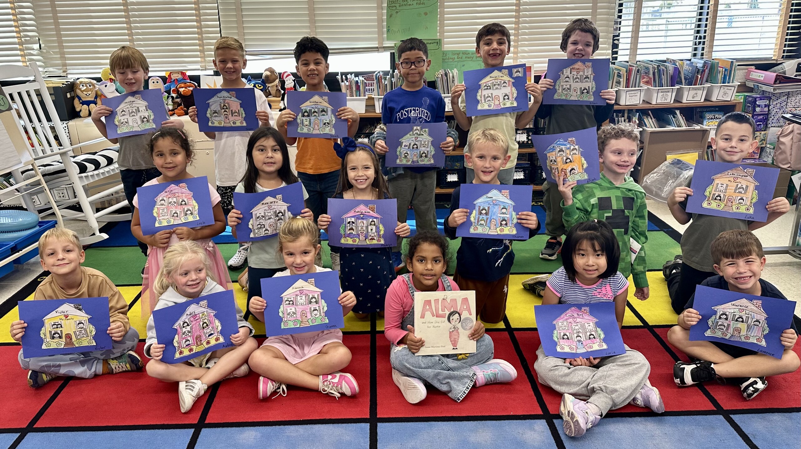 A group of young students proudly hold up their colorful art projects in a classroom.