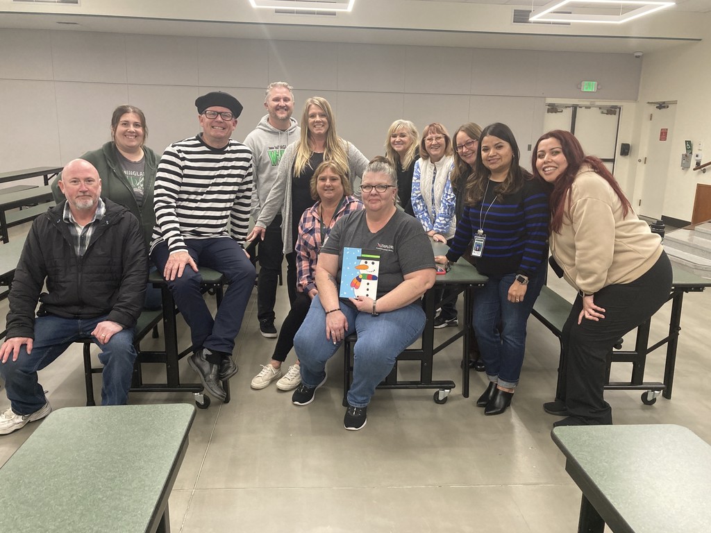 A group of individuals posing together in a classroom for a picture.