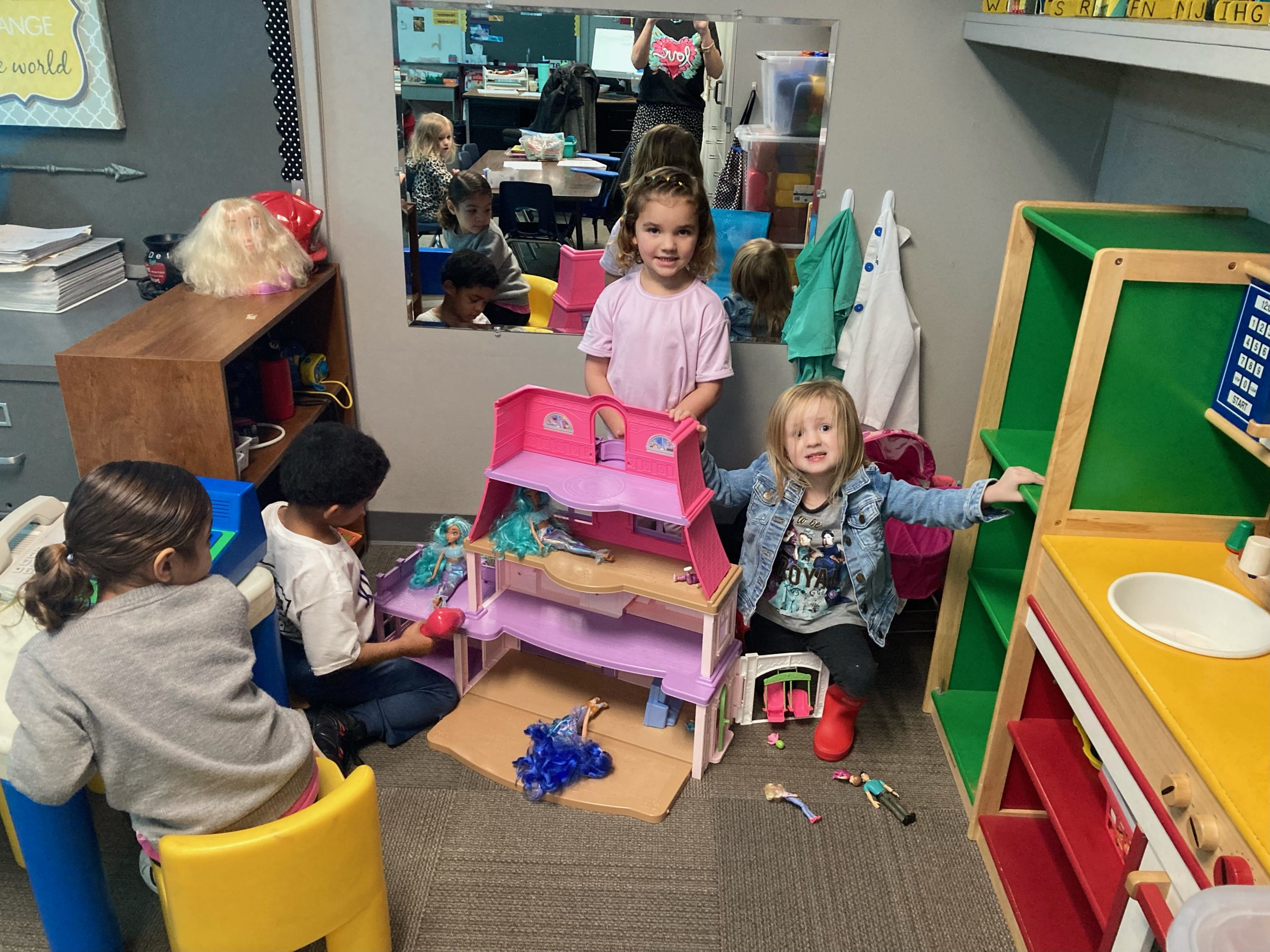 A group of children are playing with toys in a classroom.