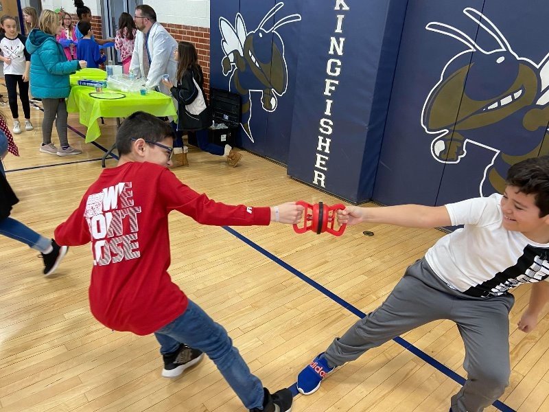 Two boys are playing a game of Rock, Paper, Scissors.