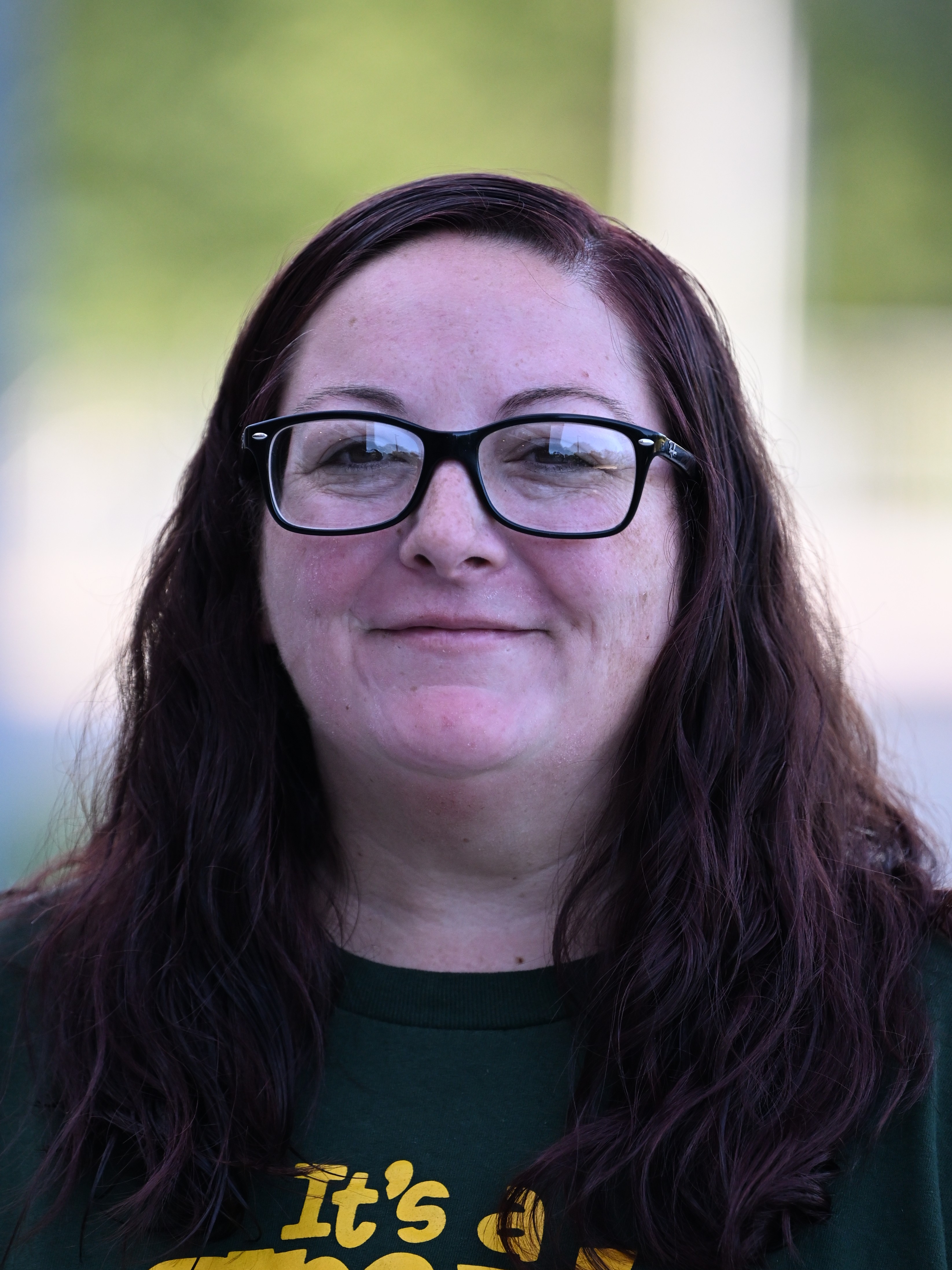 A woman with dark hair and glasses smiles at the camera.