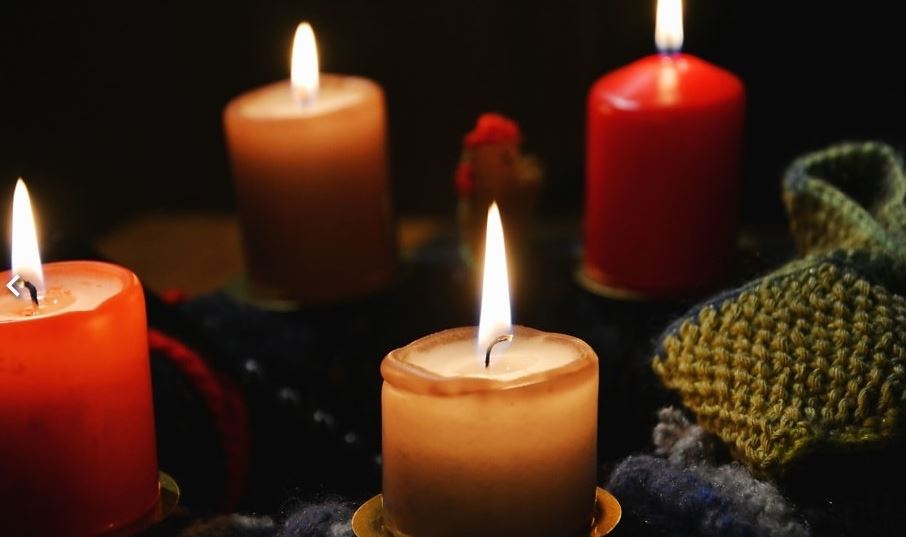 Lit candles glow warmly against a dark background.