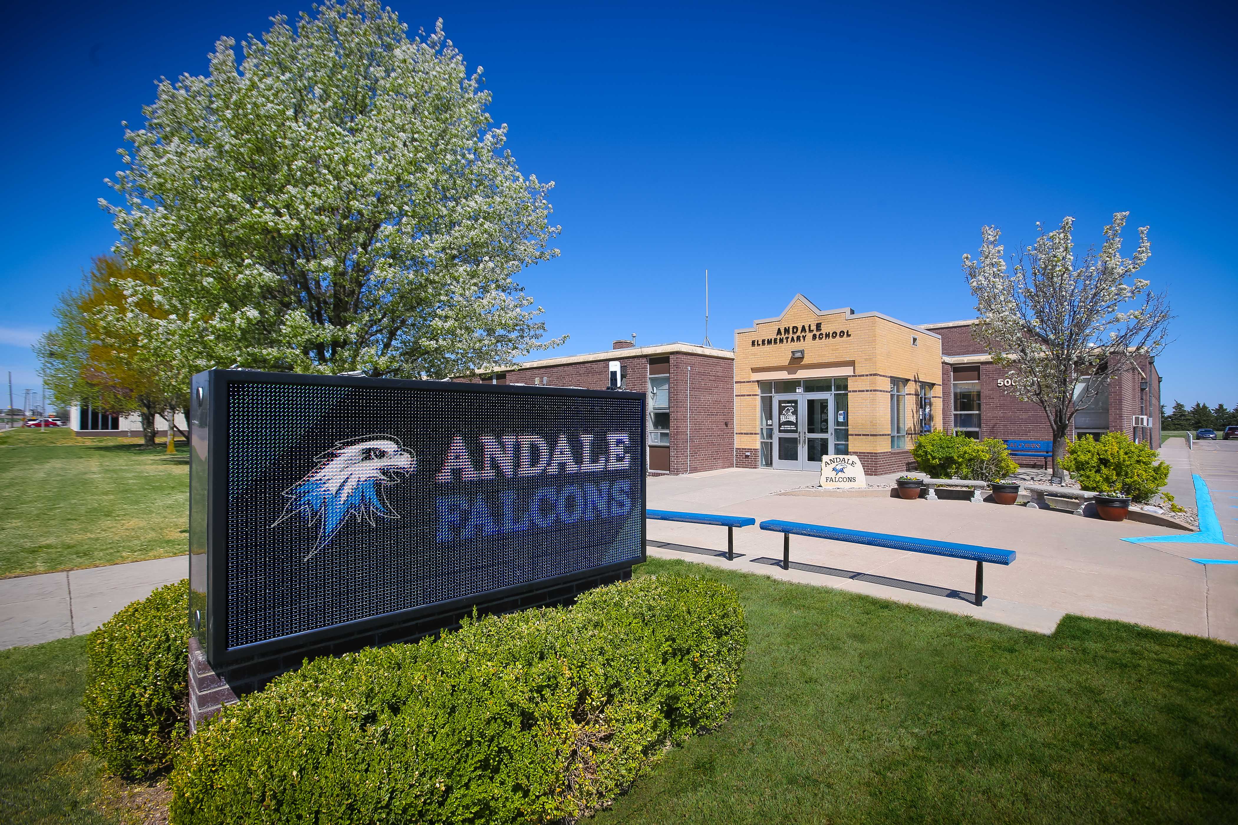 A sign for Andale High School stands in front of the school building.