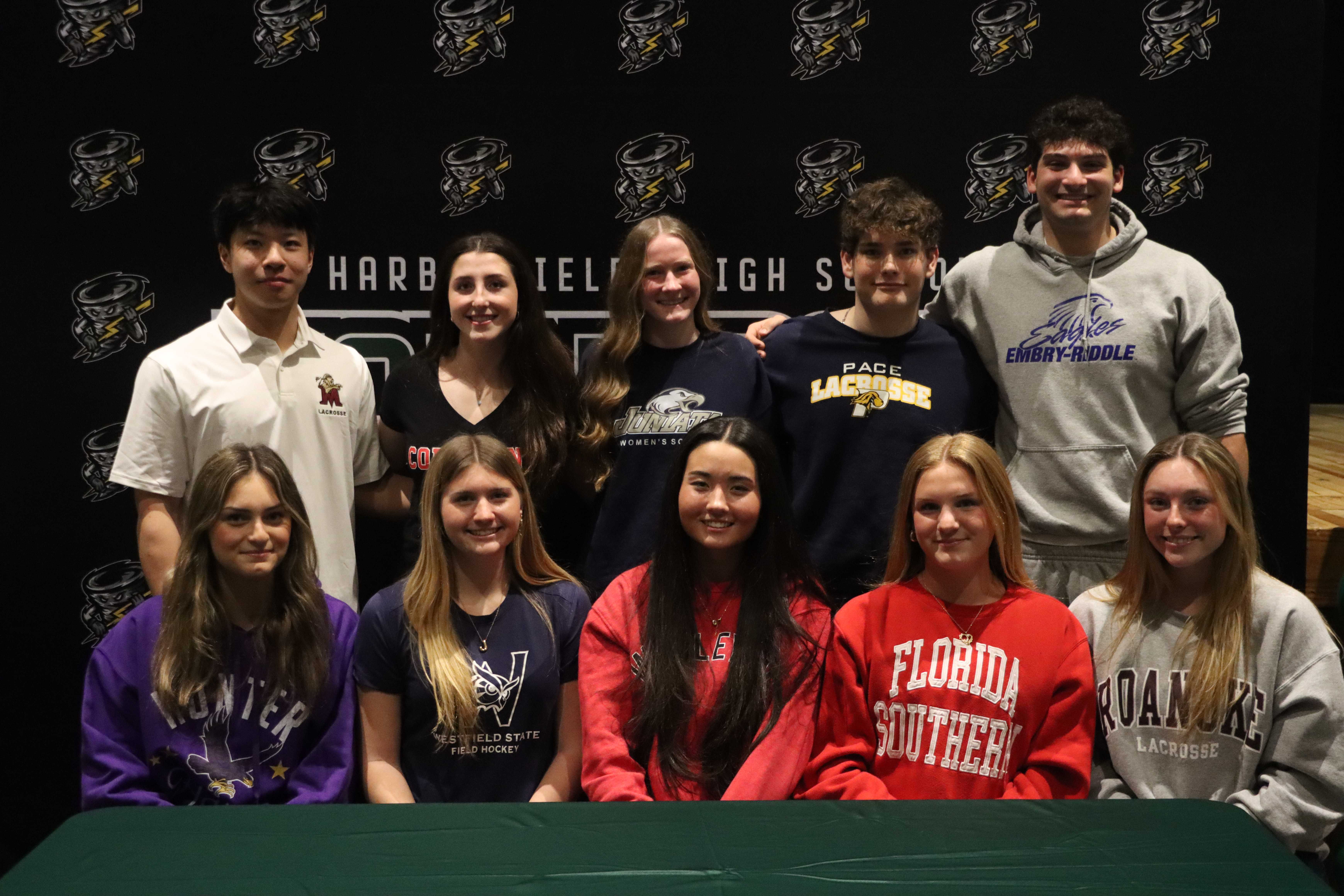 Ten student athletes pose for a photo in front of a backdrop with the text 'HARB IEL IGH SO' and tornado logos.