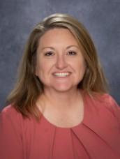 A woman with blonde hair smiles at the camera.