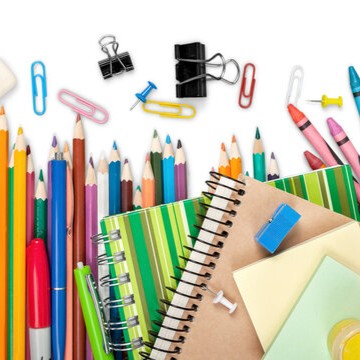 A vibrant collection of colorful pencils, crayons, notebooks, and office supplies arranged against a white background.