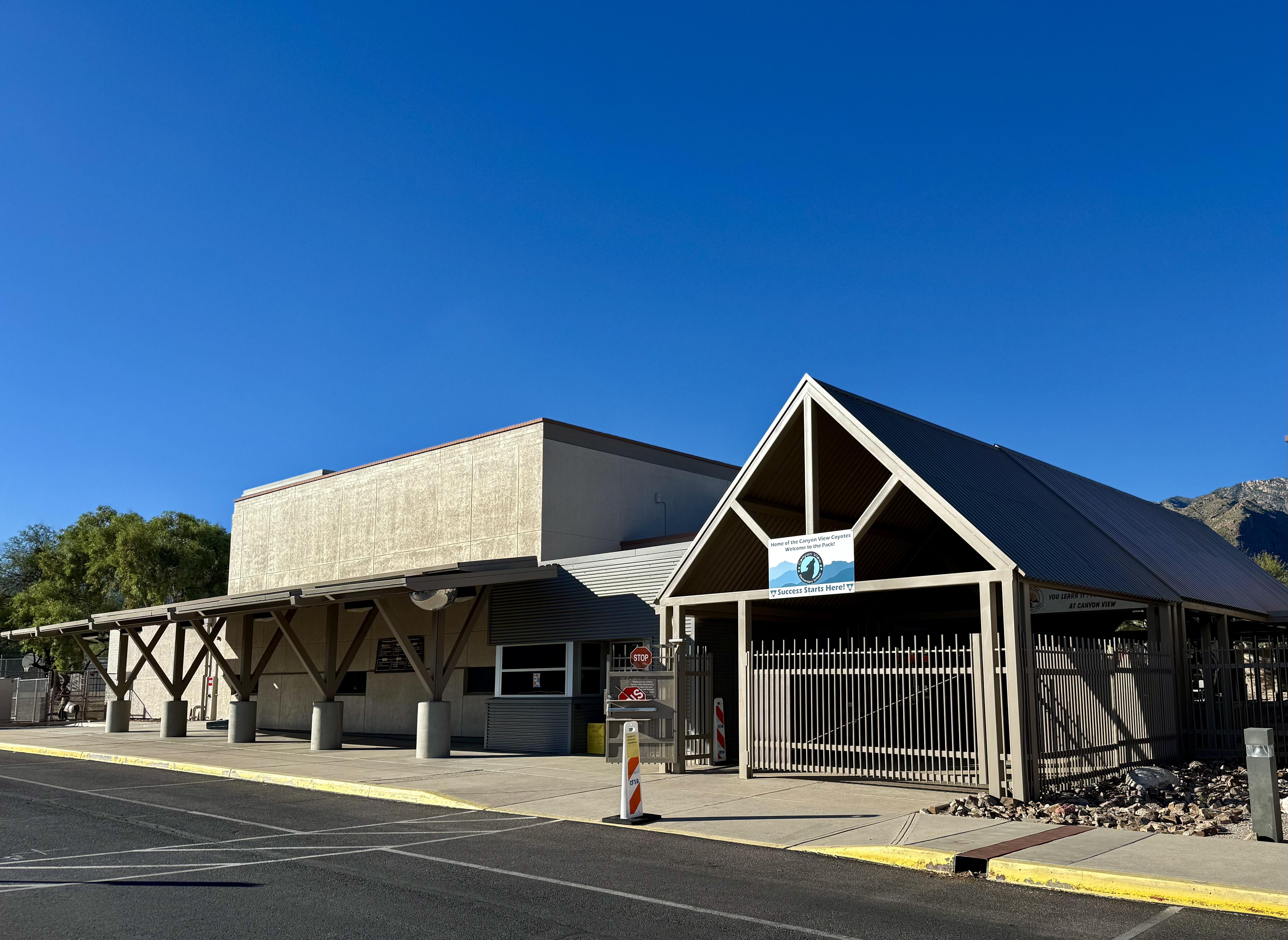 A building with a steel facade and a clear blue sky in the background.