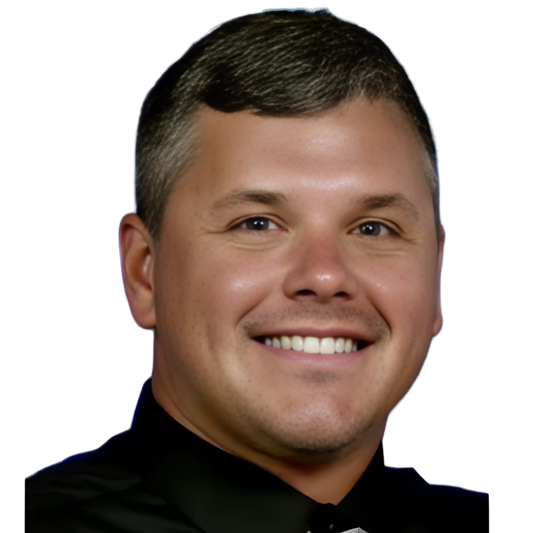 A man with short, dark hair and a friendly smile wears a black collared shirt.