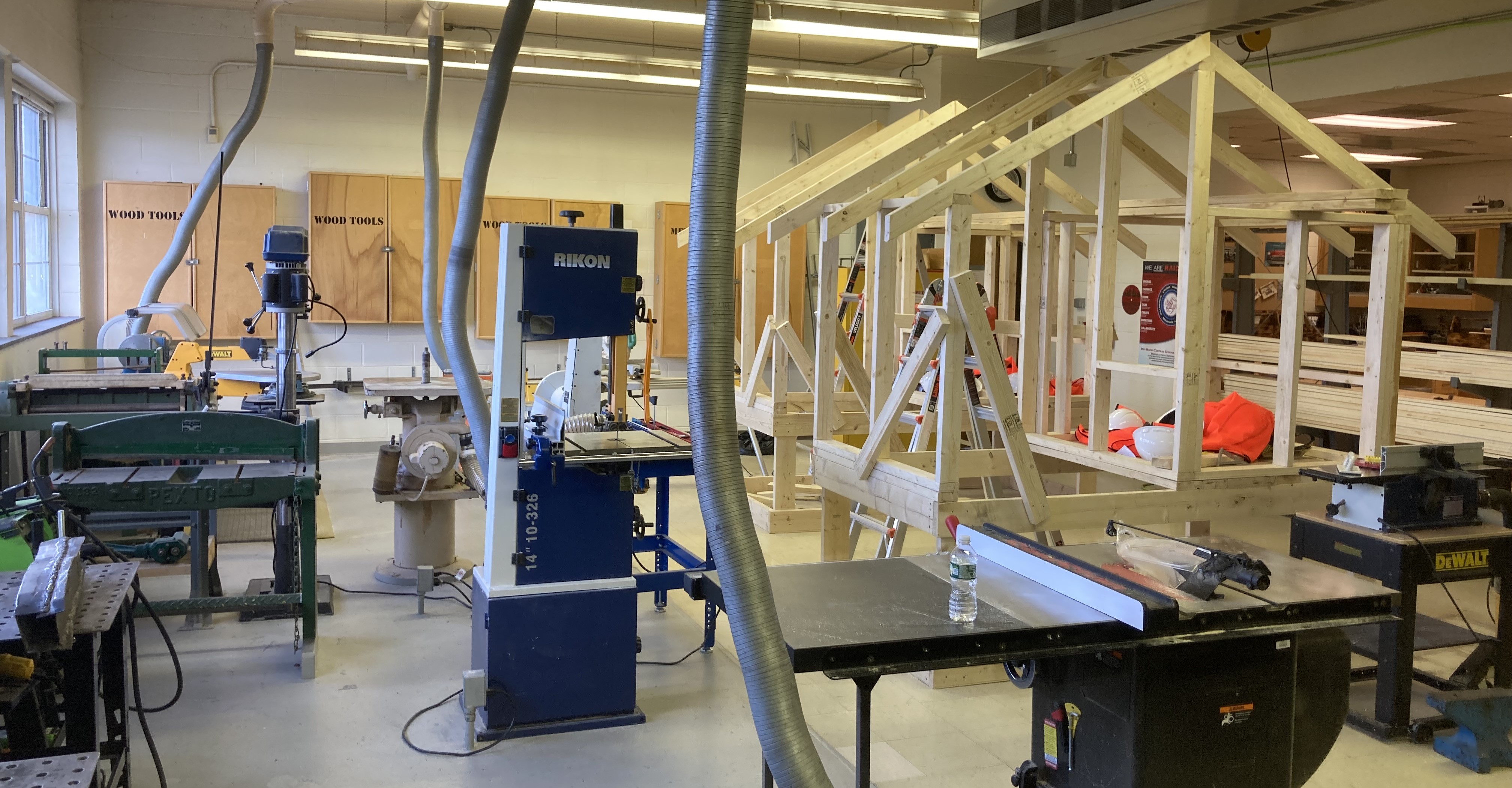 A woodworking shop with various tools and a partially built wooden structure.