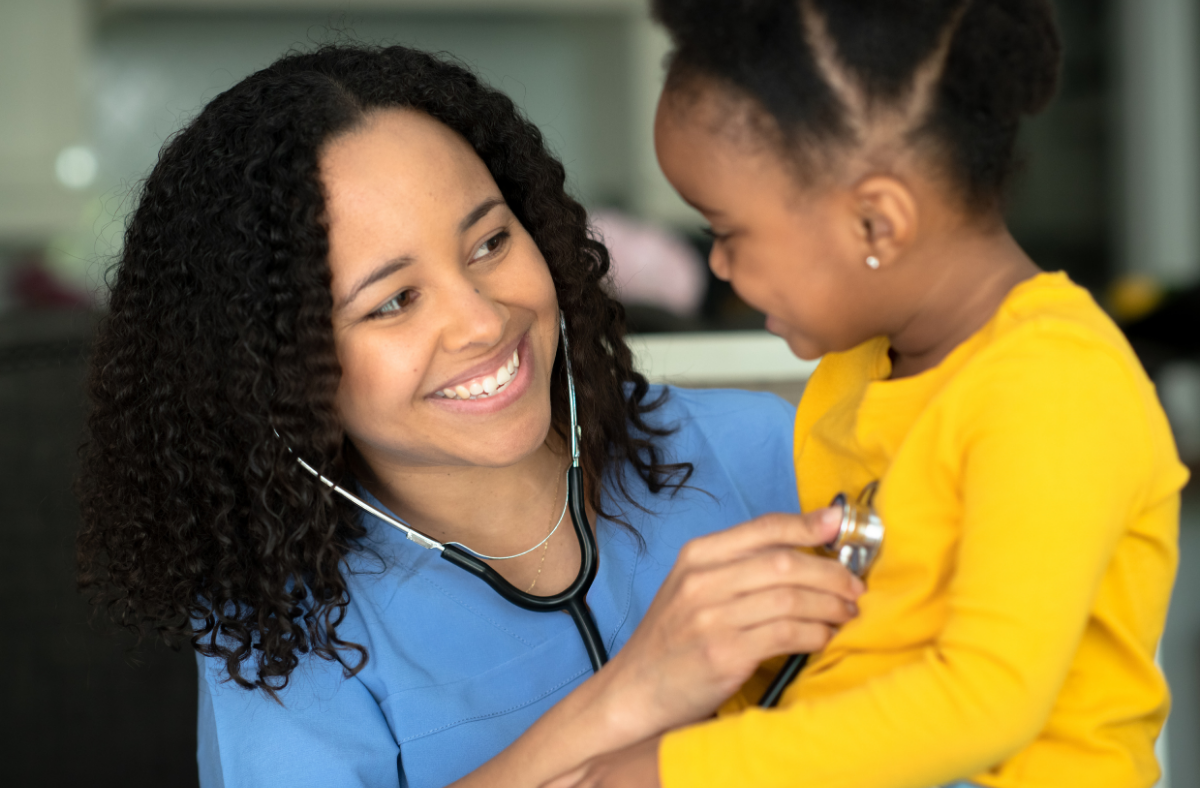 A healthcare professional listens to a young child's heartbeat with a stethoscope.