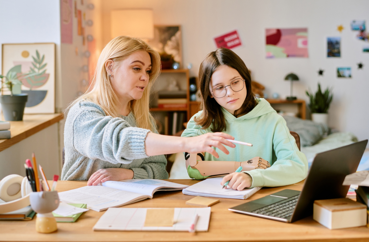 An adult and student work on homework together.