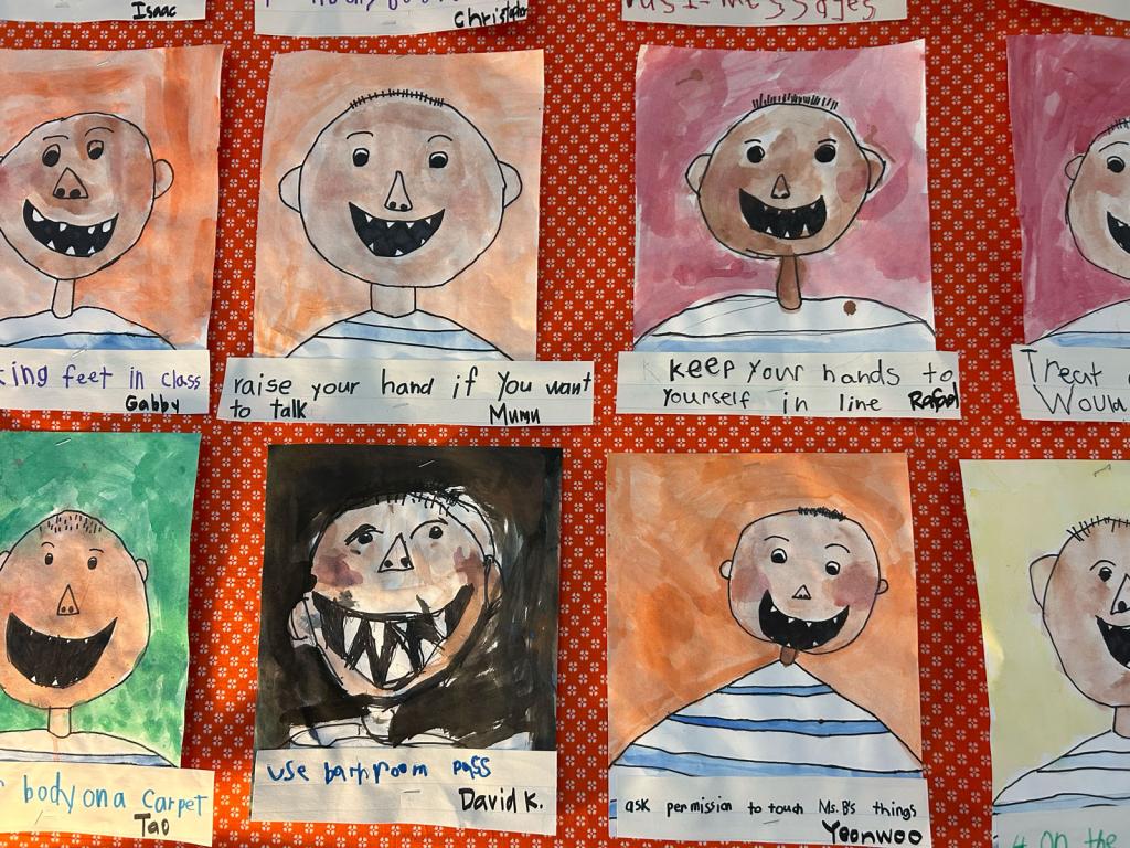 A display of colorful children's drawings of cartoon characters with wide smiles.