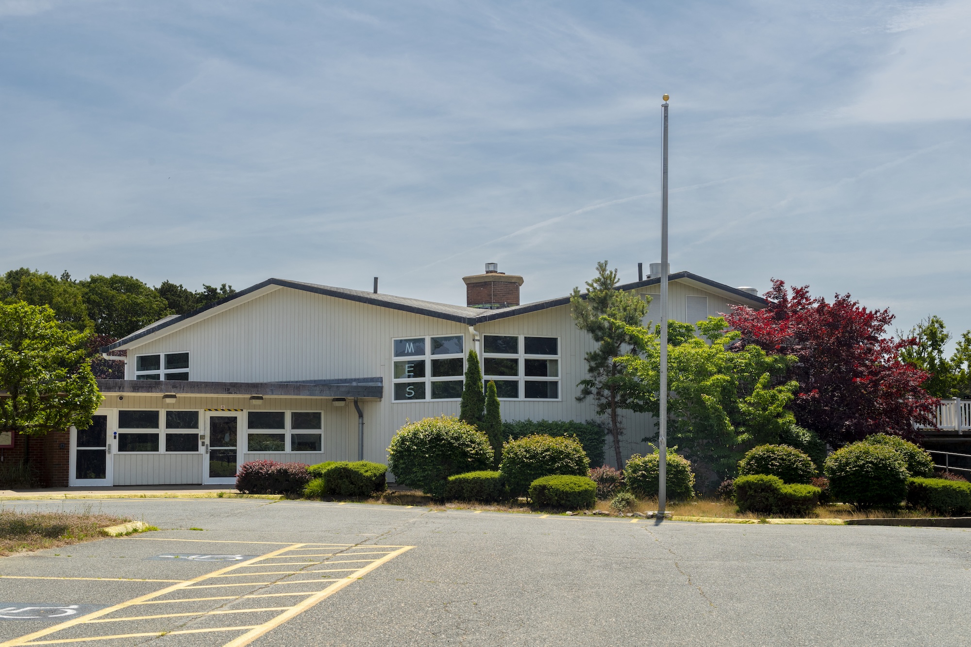 A two-story building with a white exterior and multiple windows.
