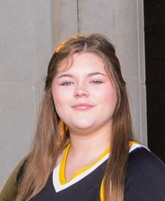 A young woman with long brown hair smiles at the camera.