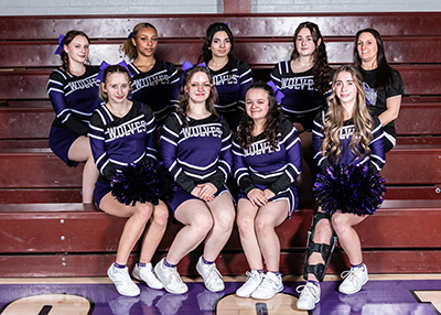 A group of cheerleaders pose together, wearing matching uniforms.