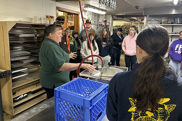 A group of people listens to a presentation in a workshop setting.