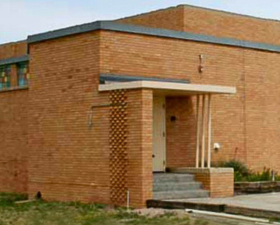 A brick building with a small covered entrance and steps.