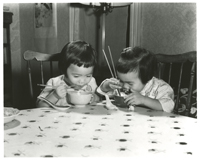2 unidentified Asian-American children eating with chop sticks 