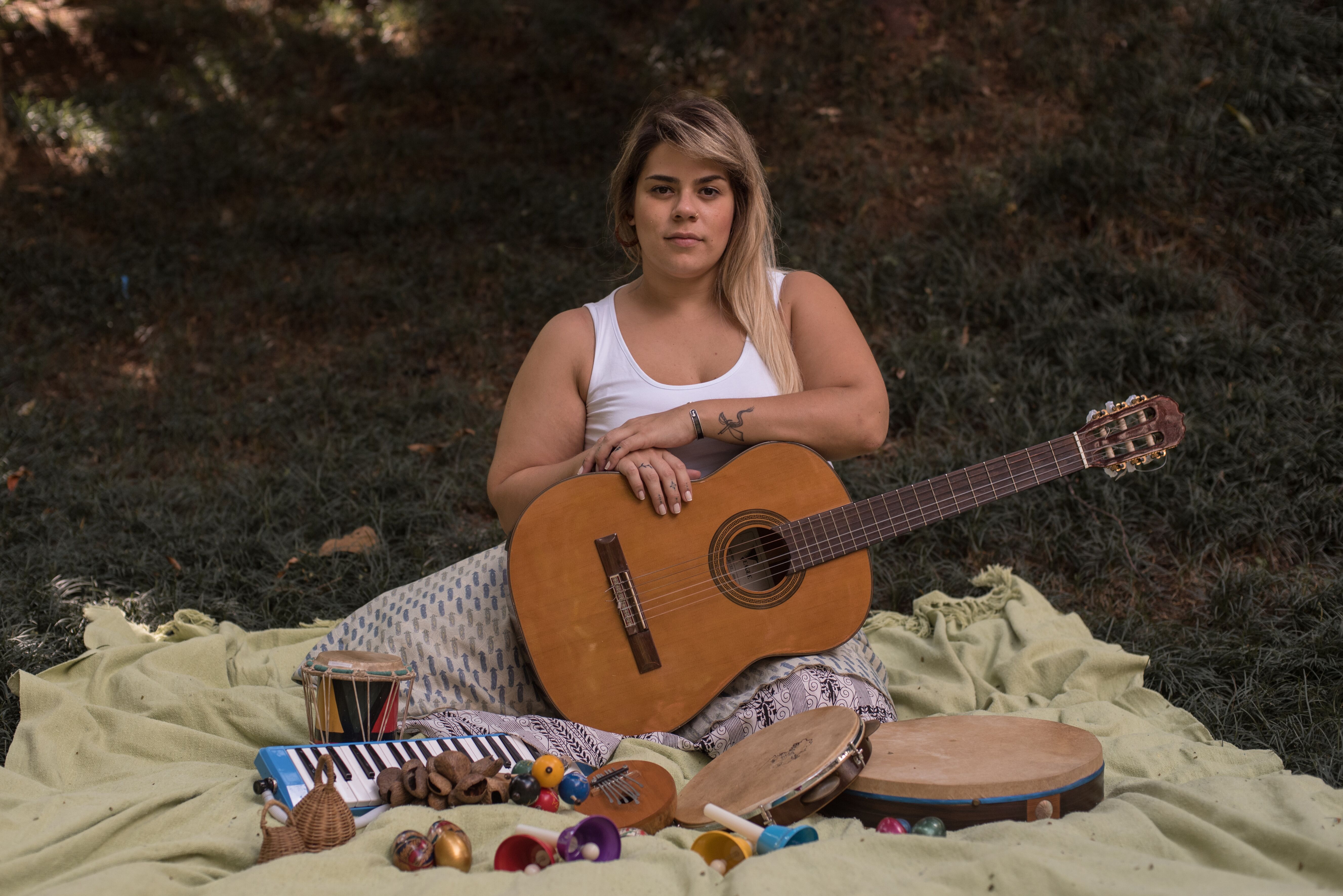 Music Therapist sitting with acoustic guitar and instruments around her