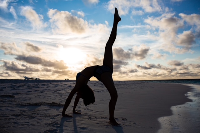 bridge yoga pose on the beach