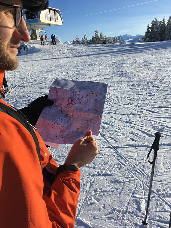 A skier looking at a printed map to navigate.