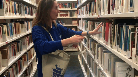 Woman throwing books into her bag