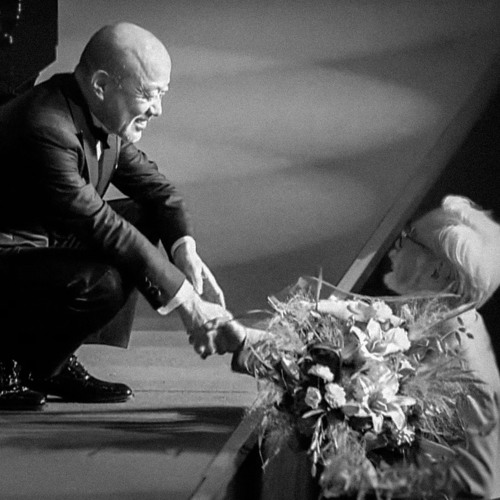 A moving image of Joe Hisaishi and Hayao Miyasaki sharing a handshake.