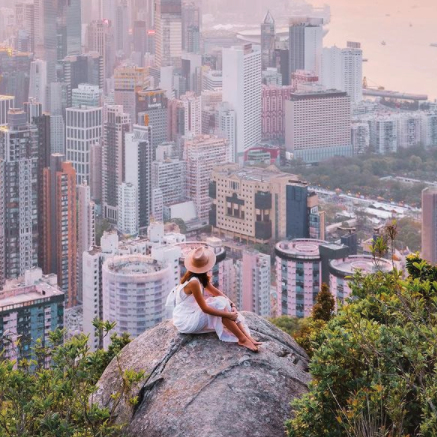 Girl sitting on a rock watching skyline