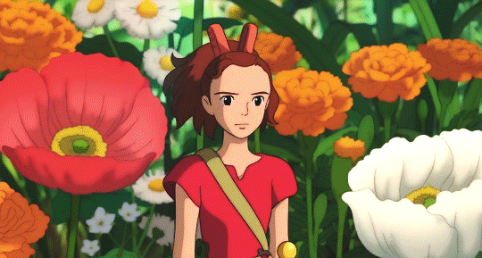 Small girl 
      standing in front of flowers