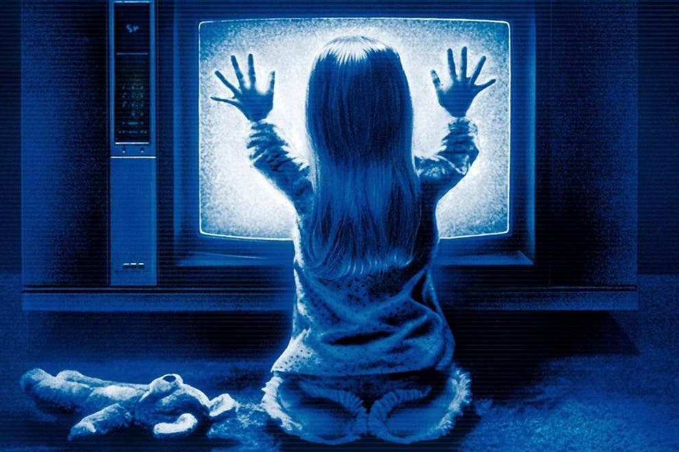 Carol Anne Freeling in front of tv with her palms touching the screen from the movie Poltergeist.