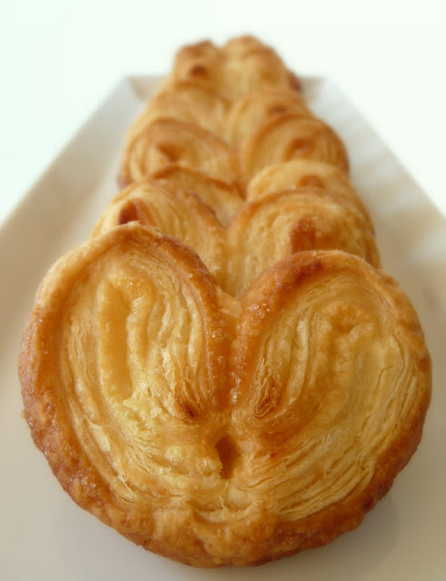 orejas aka palmeras de hojaldre stacked in a row on a platter