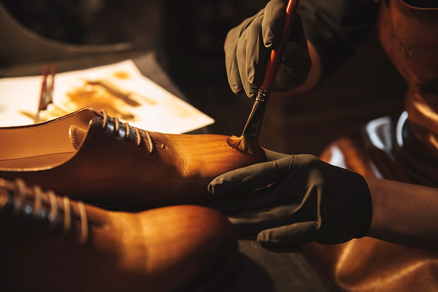 painting leather boot with brush