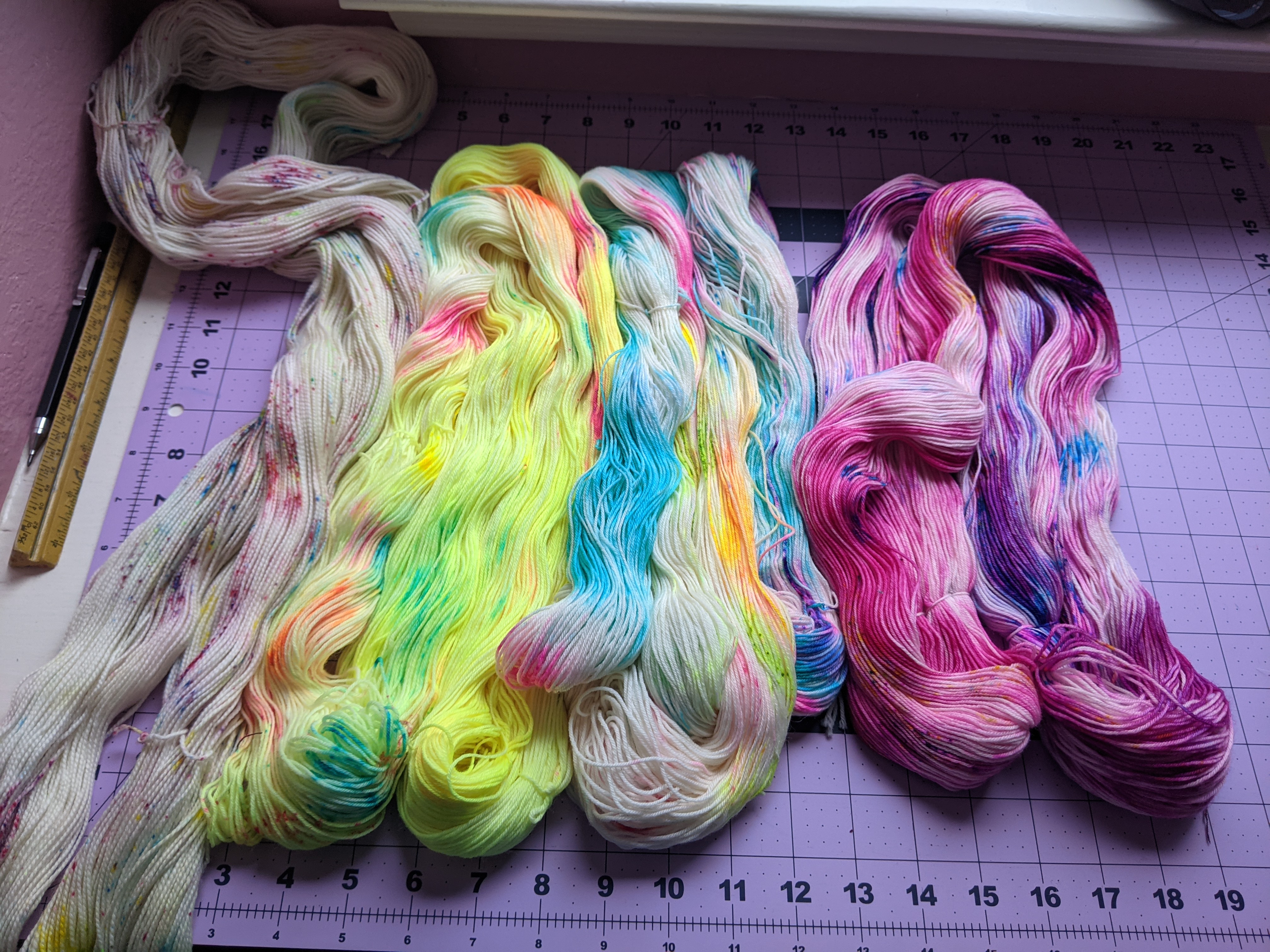 brightly colored yarn layed out on a mat