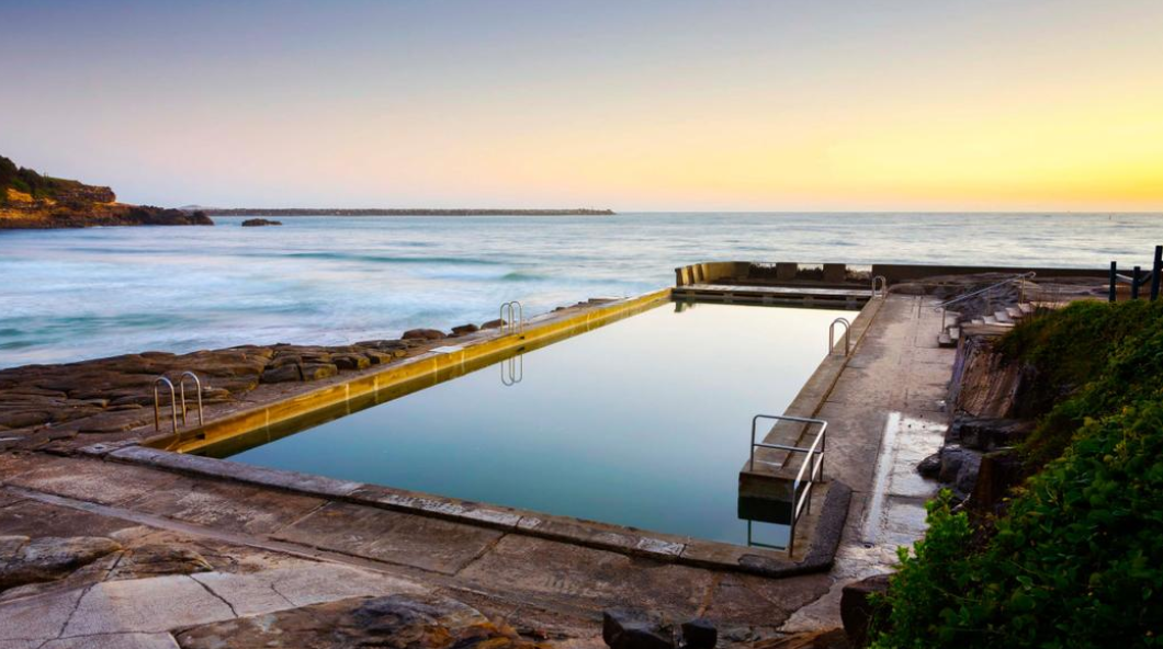 Still ocean pool with ocean in backdrop