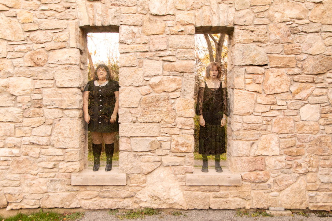 two semi-transparent women standing in the ruins of a house