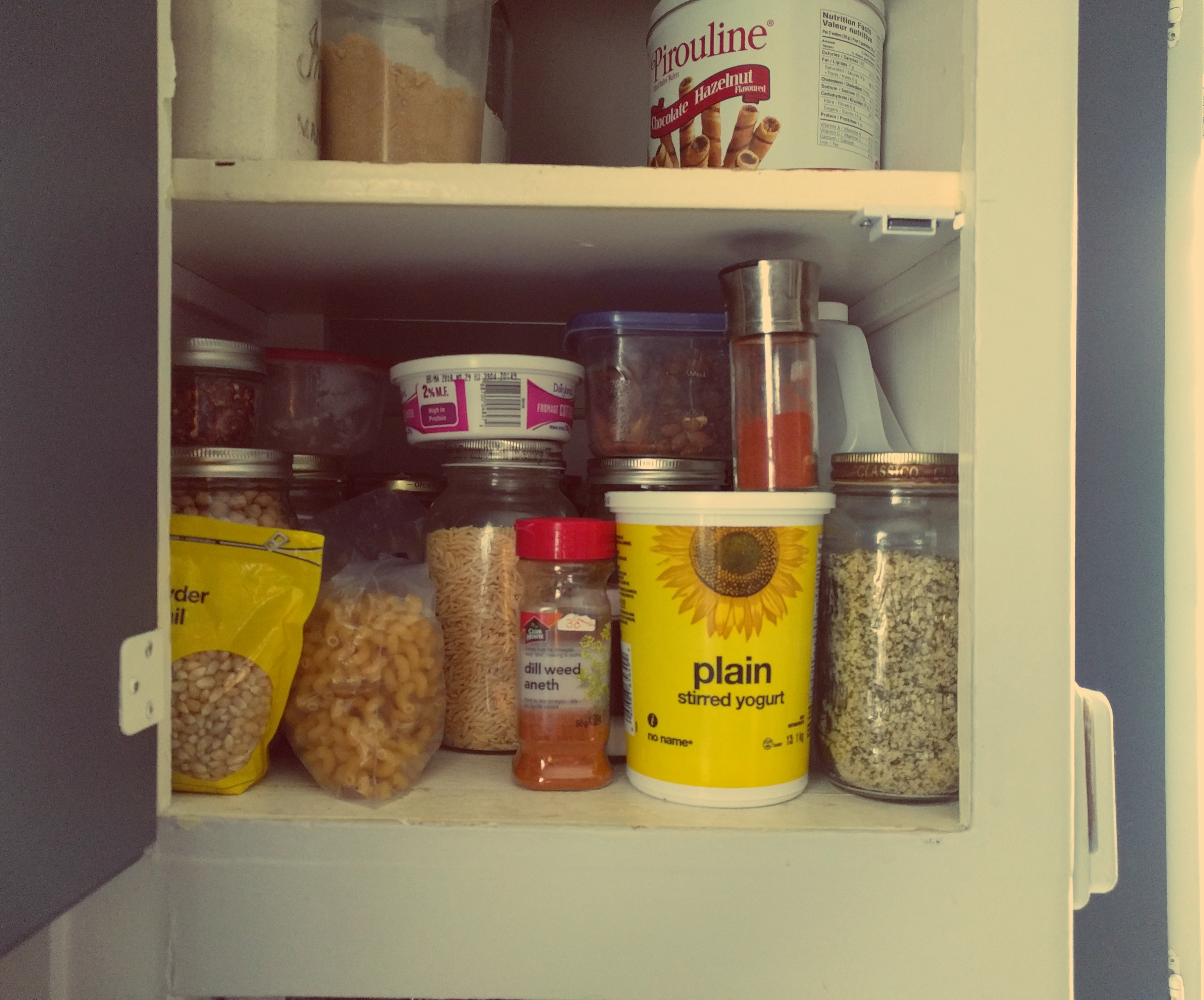 a shelf a assorted reused containers filled with food or ingredients