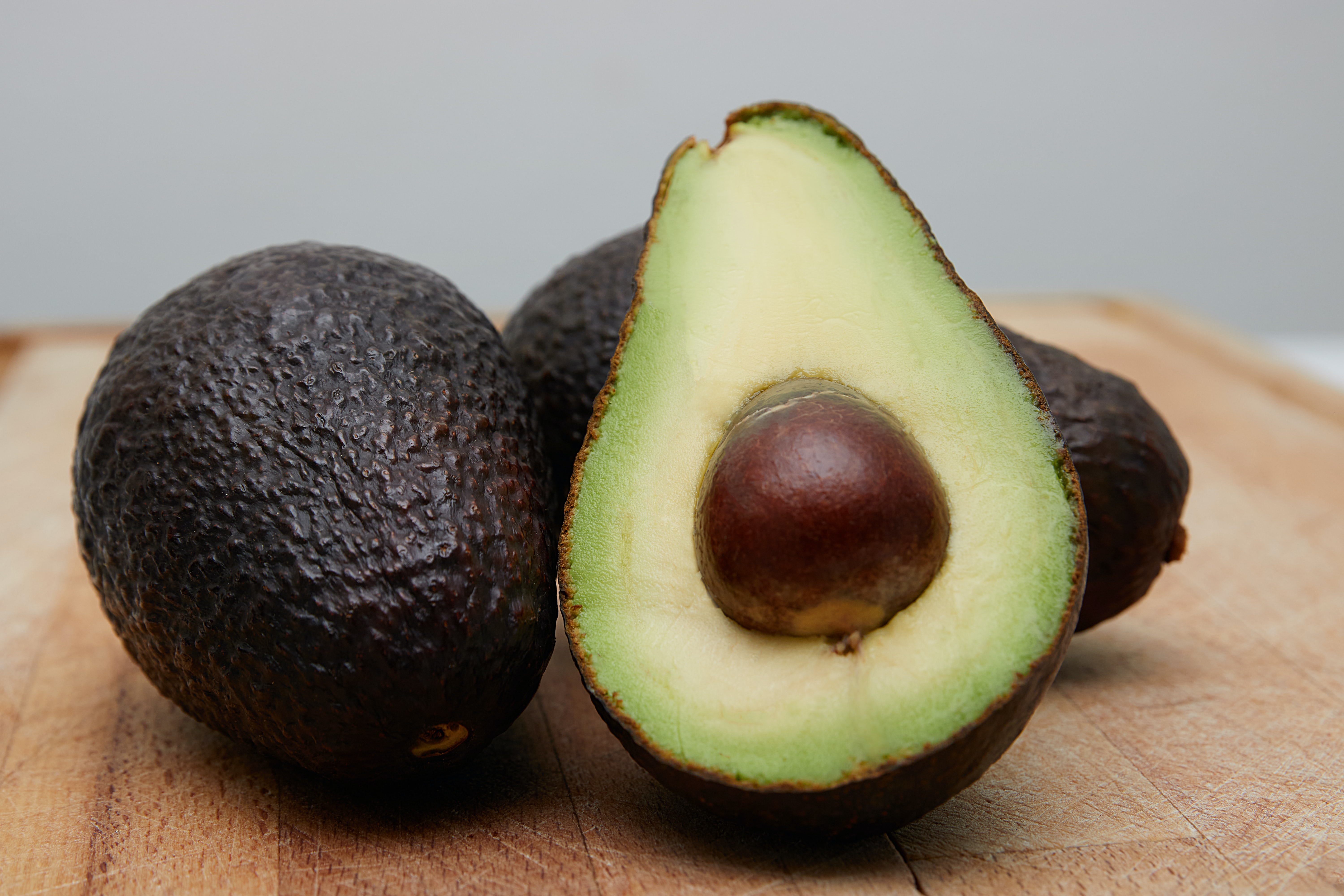 Image of an open avocado in a bunch