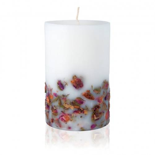 Photo of a white candle with rose petles on its base