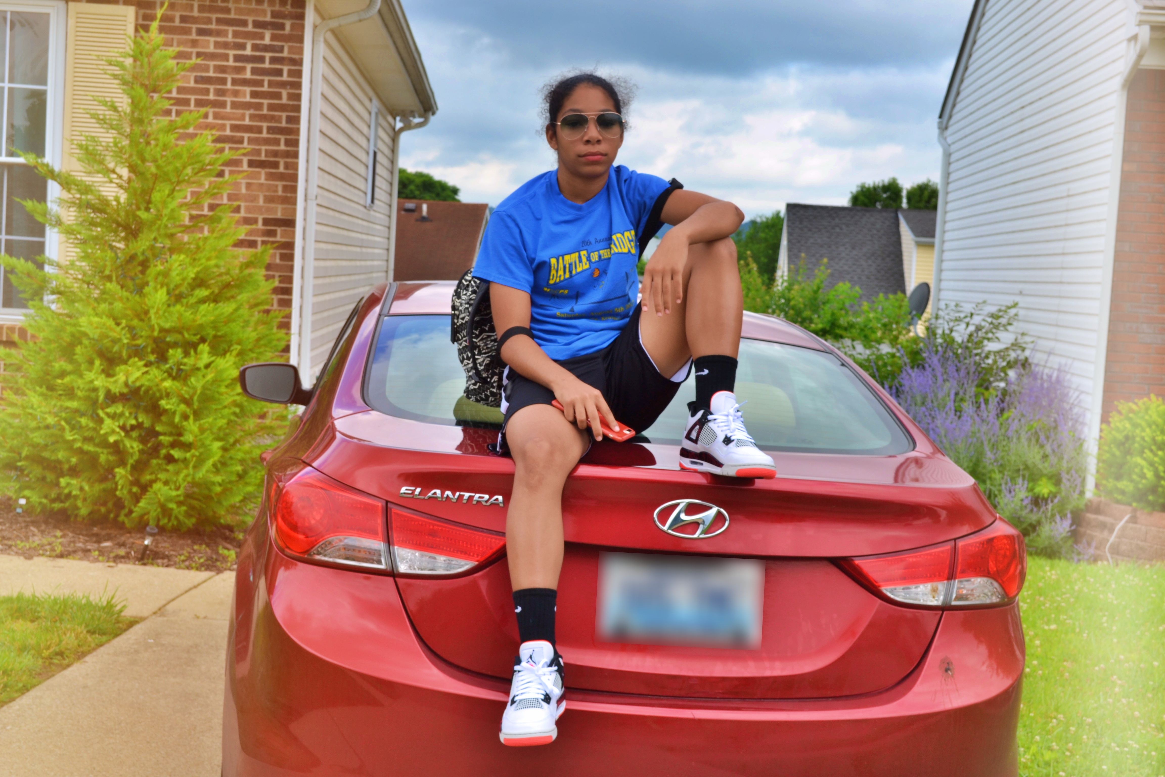 Girl sitting on red car