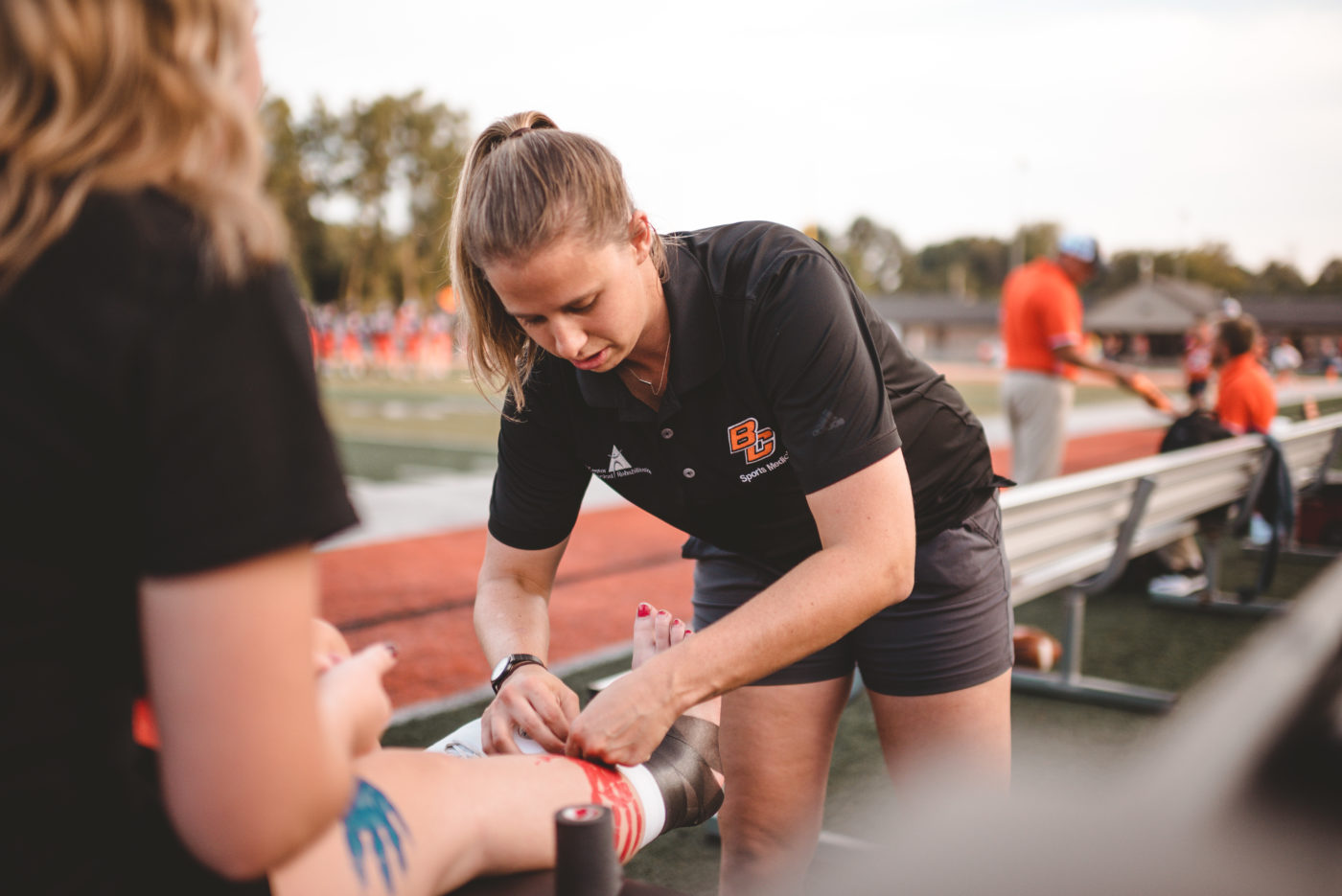 Female Athletic Trainer taping ankle