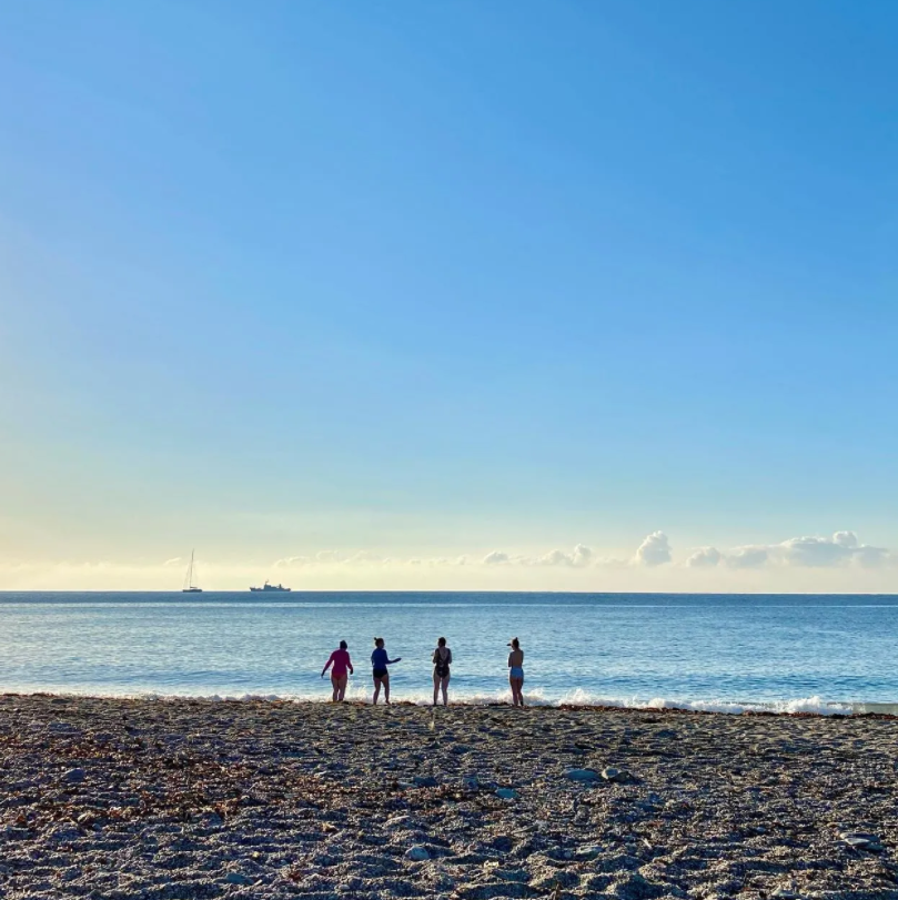 four women walking into the sea to go swimming