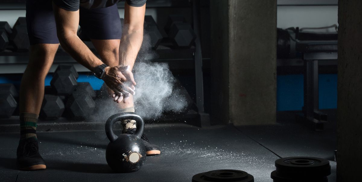 Person powdering hands before lifting kettlebell
