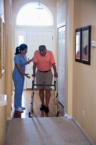 Female therapist assisting patient with ambulation in the home using FWW