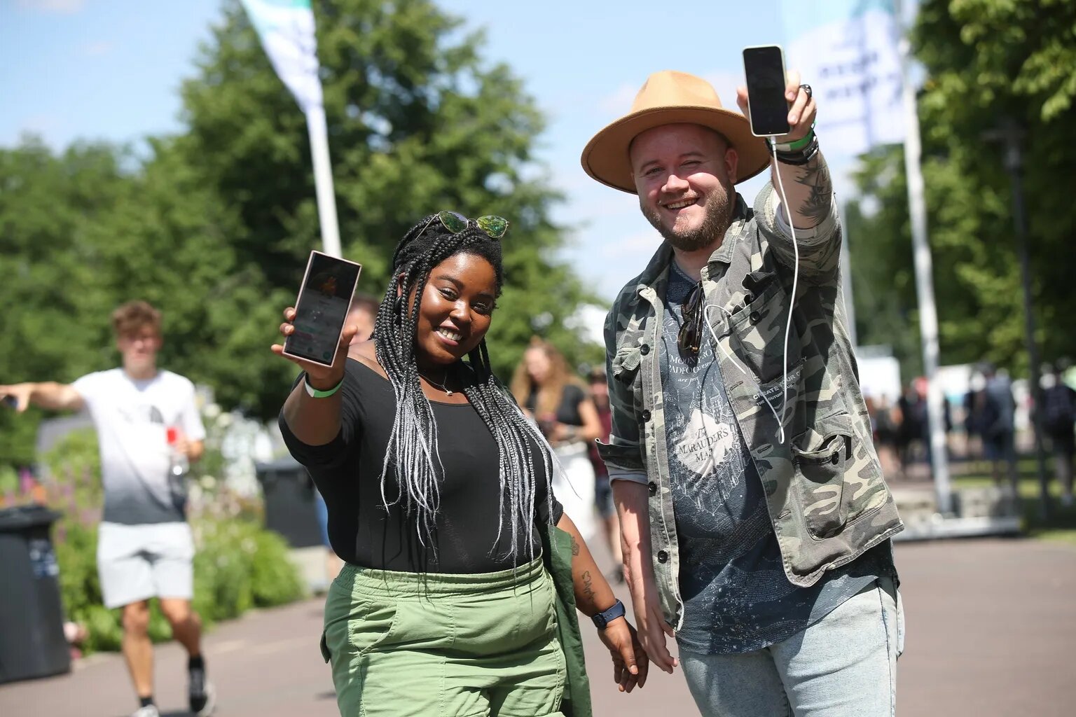 2 people smiling and holding hands and showing the Pokemon Go app on their phones