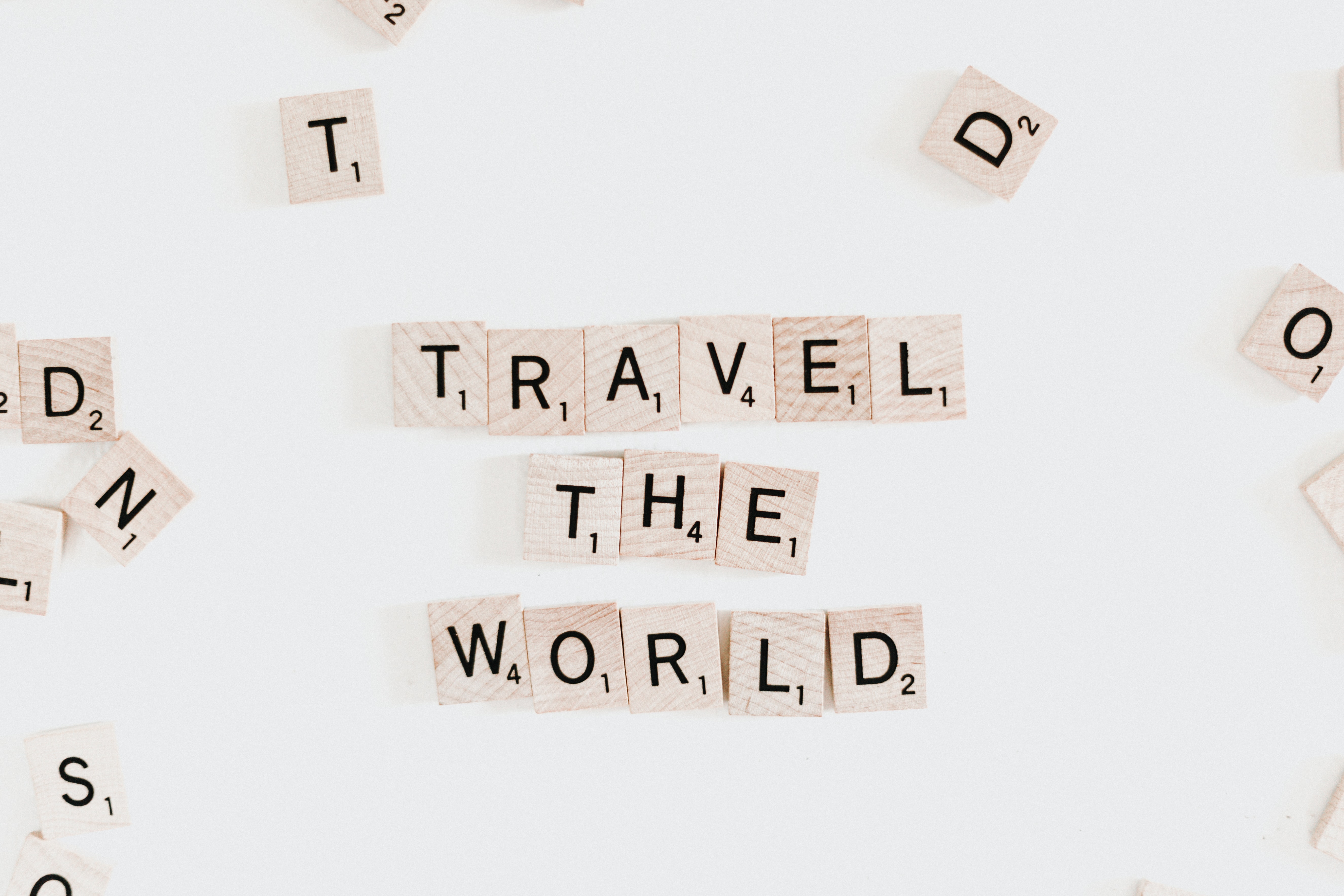 scrabble letters spelling 'travel the world'