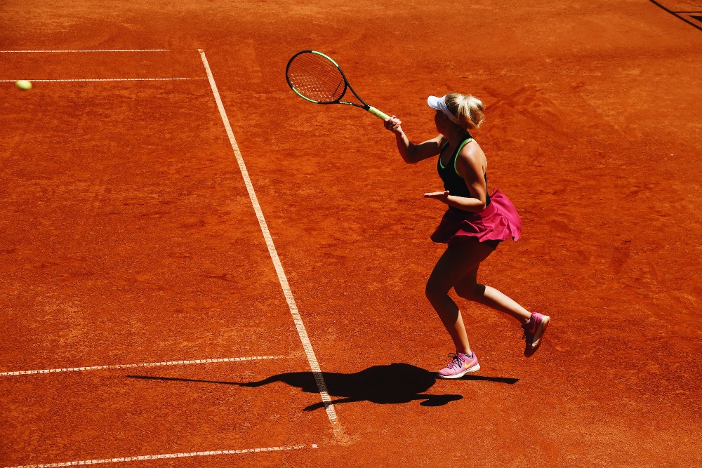 A women playing tennis on clay court surface